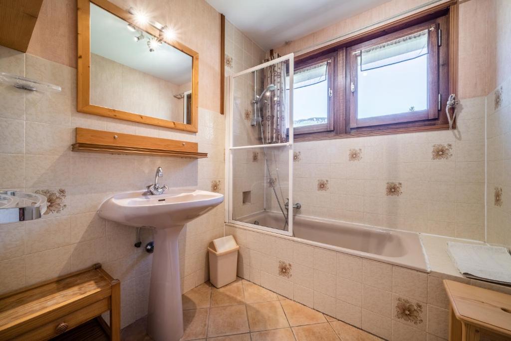 une salle de bain avec un lavabo et une baignoire dans l'établissement Apt Chénives 1 - Morzine, à Morzine 17 autres photos