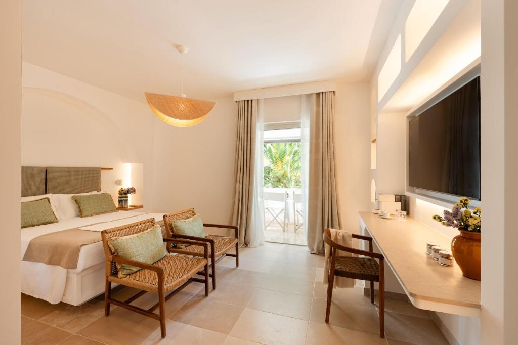 une chambre d'hôtel avec un lit, une table et des chaises dans l'établissement Ostuni a Mare, à Ostuni