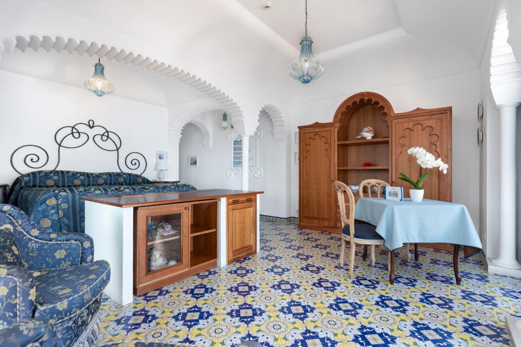 une chambre avec un lit, une table et des chaises dans l'établissement Hotel La Tonnarella, à Sorrente