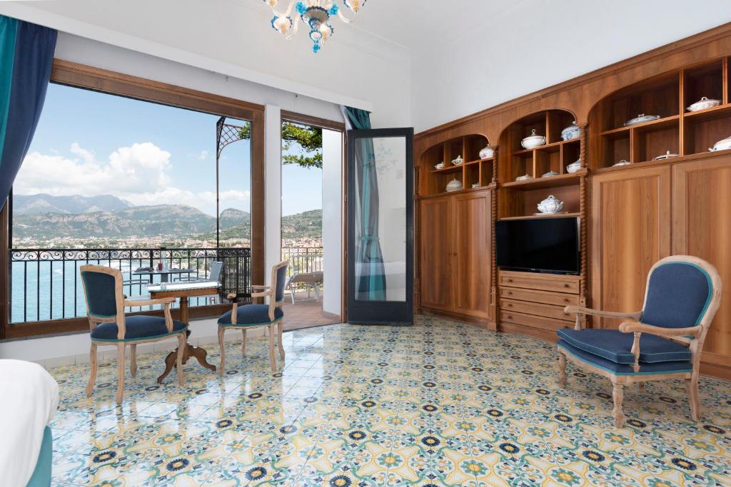 Cette chambre comprend un lit, une télévision et des chaises. dans l'établissement Hotel La Tonnarella, à Sorrente