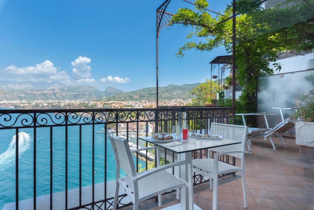 - un balcon avec une table, des chaises et l'eau dans l'établissement Hotel La Tonnarella, à Sorrente