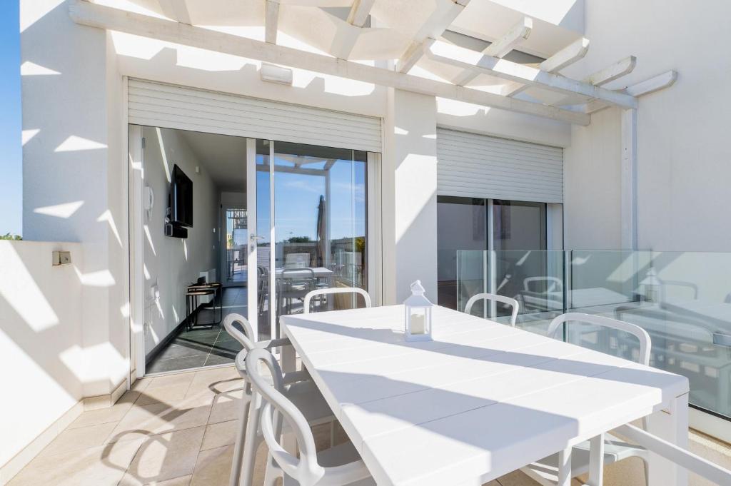 une salle à manger blanche avec une table et des chaises blanches dans l'établissement Villa Venza , Salento, à Otrante