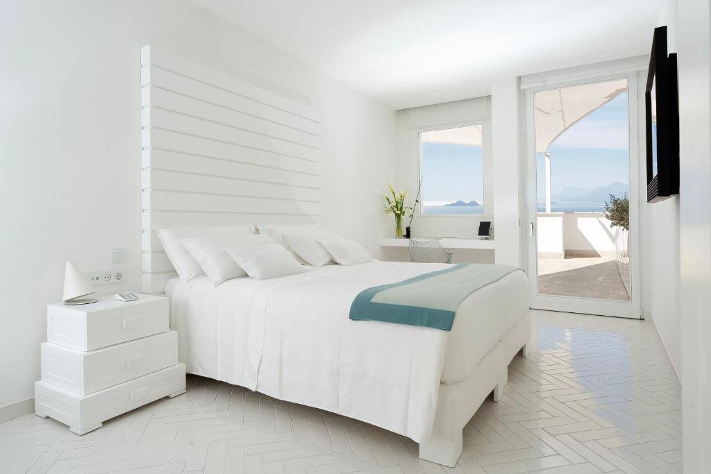 une chambre blanche avec un lit blanc et une fenêtre dans l'établissement Casa Angelina, à Praiano 58 autres photos