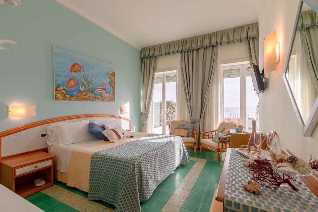 une chambre avec un lit et un salon dans l'établissement Grand Hotel Il Ninfeo, à Gaète