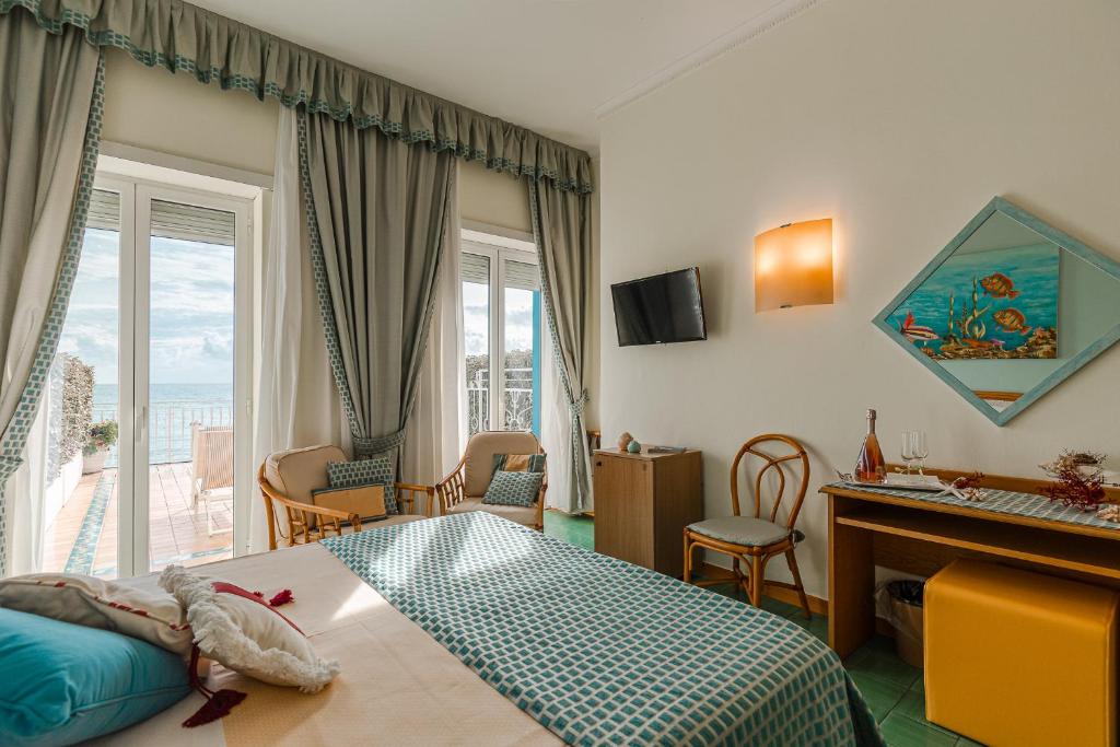 une chambre d'hôtel avec un lit et un bureau et une chambre dans l'établissement Grand Hotel Il Ninfeo, à Gaète 186 autres photos