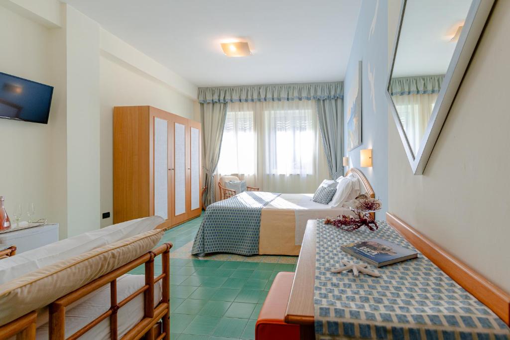 une chambre avec deux lits et un canapé dans l'établissement Grand Hotel Il Ninfeo, à Gaète