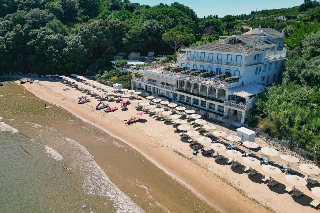 - une vue aérienne sur une plage avec des parasols et un bâtiment dans l'établissement Grand Hotel Il Ninfeo, à Gaète