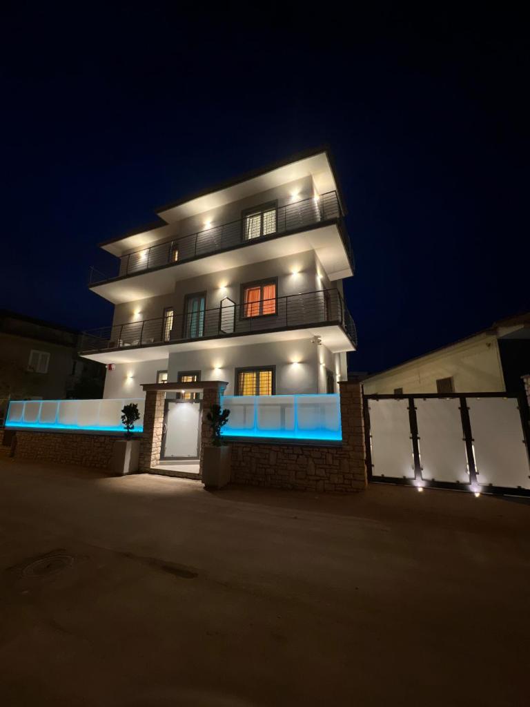 un grand bâtiment avec des lumières allumées la nuit dans l'établissement Domus Marina - Baltico Apartment, à Mondragone