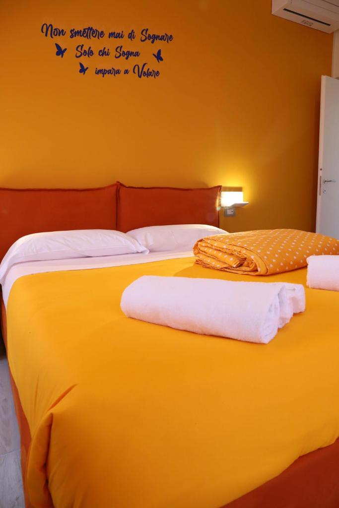 une chambre avec deux lits avec des mots sur le mur dans l'établissement Domus Marina - Egeo Apartment, à Mondragone 34 autres photos