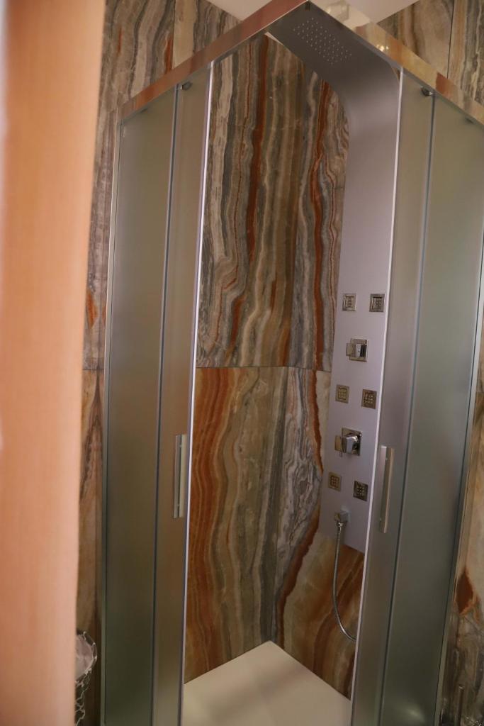 une douche avec une porte vitrée dans une salle de bain dans l'établissement Domus Marina - Egeo Apartment, à Mondragone