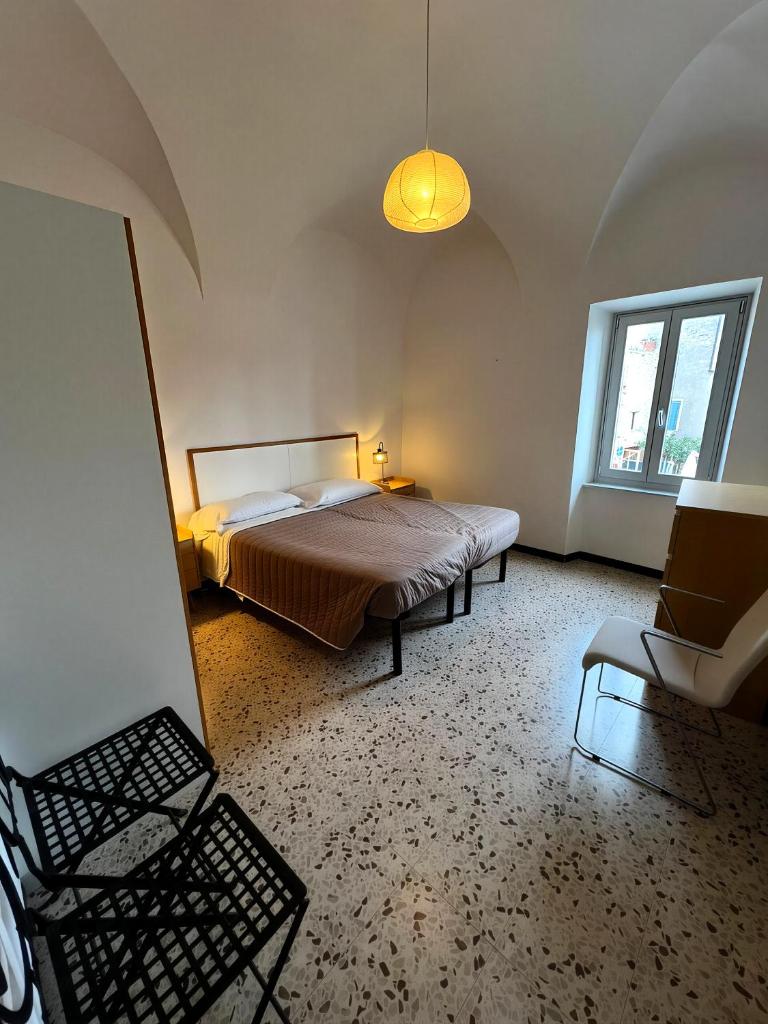 une chambre avec un lit et une chaise dedans dans l'établissement Casa del Teatro, à Borgio Verezzi