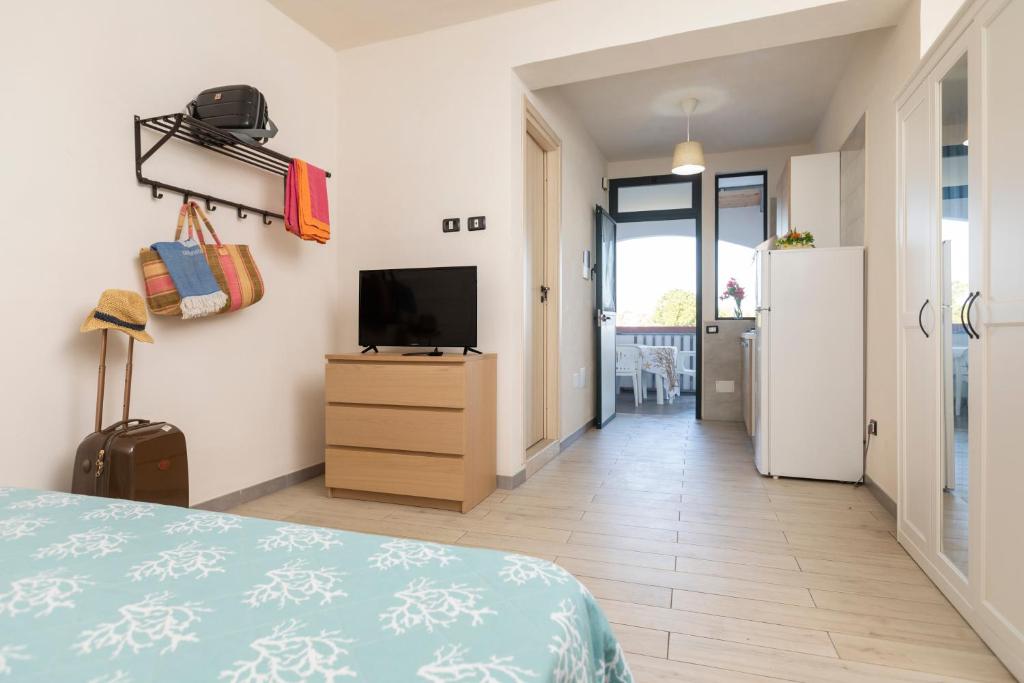 Cette chambre comprend un lit, une télévision et un réfrigérateur. dans l'établissement Village La Canzone del Mare, à Vieste