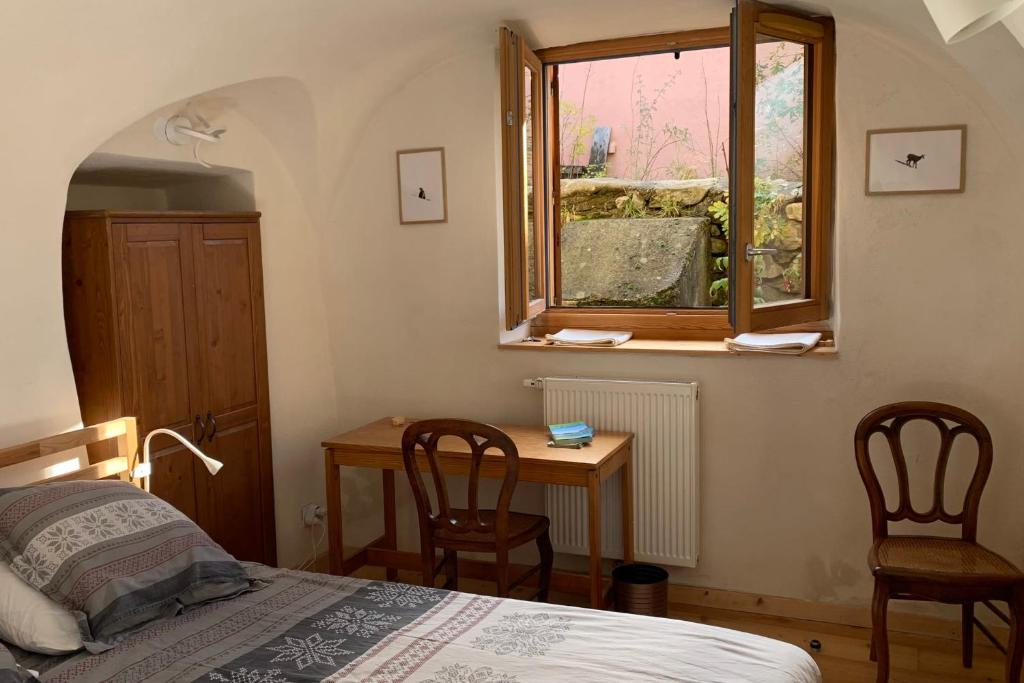 une chambre avec un lit, un bureau et une fenêtre dans l'établissement Village House In The Heart Of Saint Chaffrey, à Saint-Chaffrey