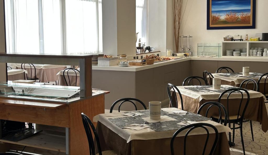 un restaurant avec des tables et des chaises et une cuisine dans l'établissement Hotel Mirage, à Lido di Jesolo