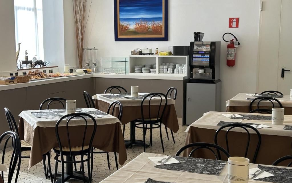 un restaurant avec des tables et des chaises dans une cuisine dans l'établissement Hotel Mirage, à Lido di Jesolo 29 autres photos