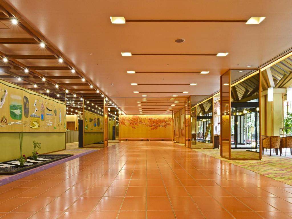 un couloir vide dans un bâtiment aux murs jaunes dans l'établissement jyozankei SHIKAnoYU, à Jozankei 40 autres photos