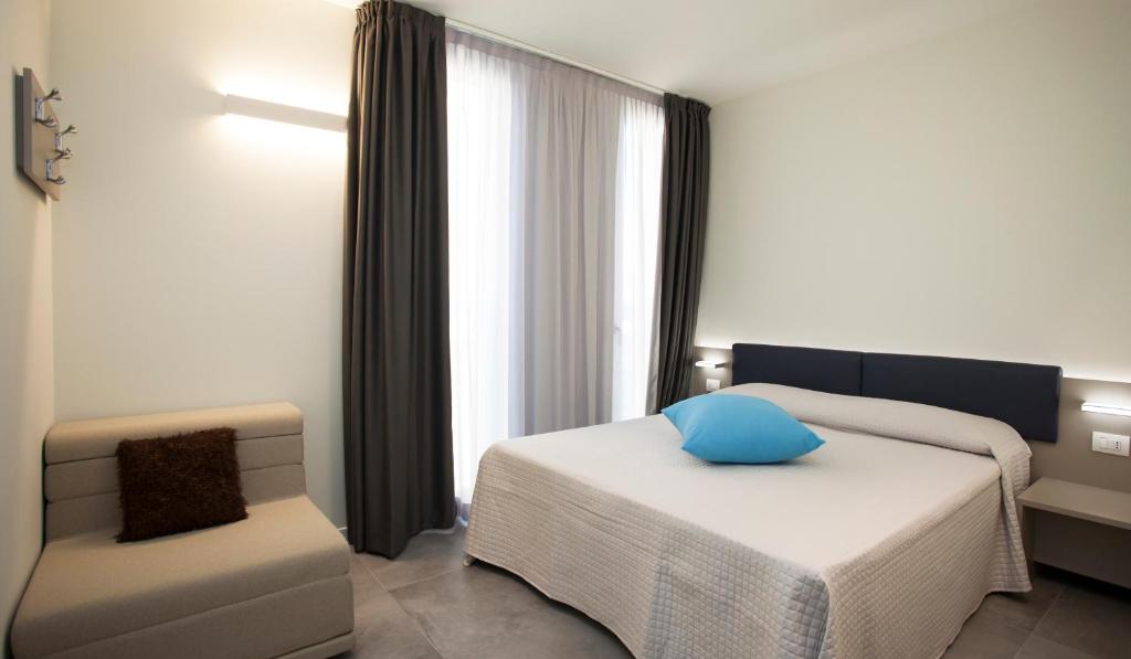 une chambre d'hôtel avec un lit et une chaise dans l'établissement Residence Panama, à Lido di Jesolo 85 autres photos