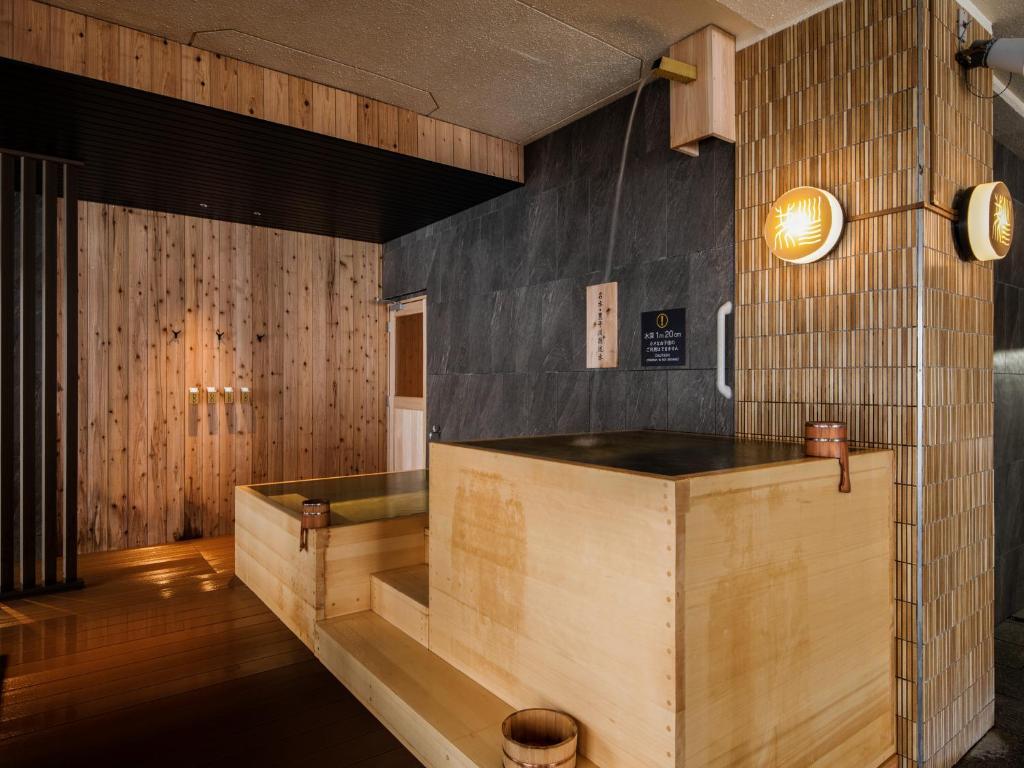 - un restaurant avec un comptoir en bois dans une chambre dans l'établissement jyozankei SHIKAnoYU, à Jozankei