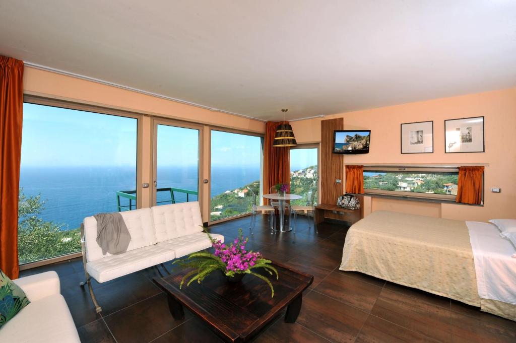 une chambre avec un lit et de grandes fenêtres dans l'établissement Villa Solaria, à Massa Lubrense