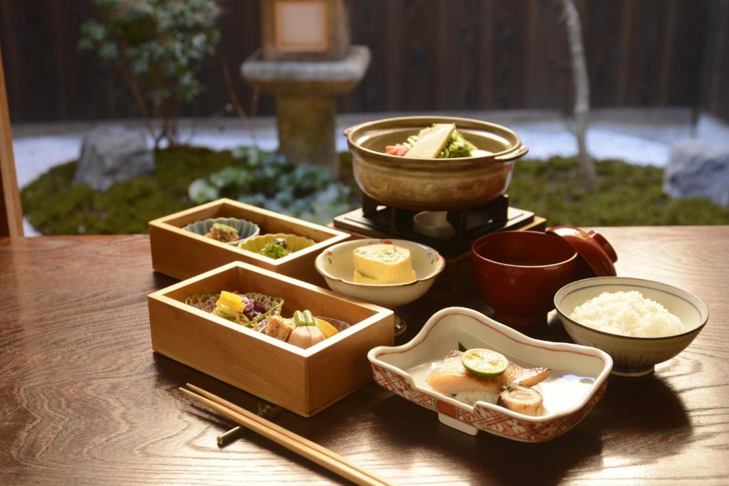 une table recouverte de bols de nourriture et de baguettes dans l'établissement Mitsuki Kyoto, à Kyoto