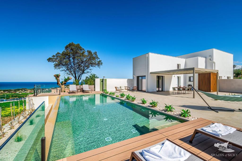 une villa avec piscine devant une maison dans l'établissement Villa Castello, à Balestrate