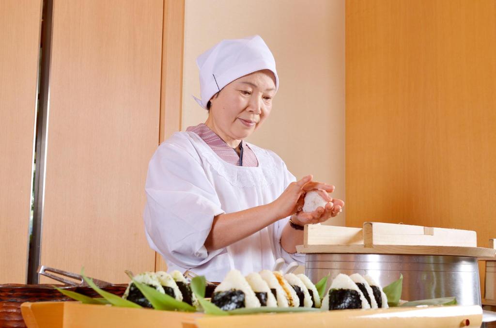 une femme en tenue de chef préparant de la nourriture dans l'établissement Shoho, à Matsumoto 37 autres photos