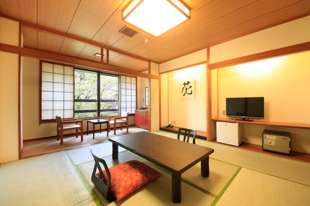 un salon avec une table et une télévision dans l'établissement Yutorelo-an, à Hakone