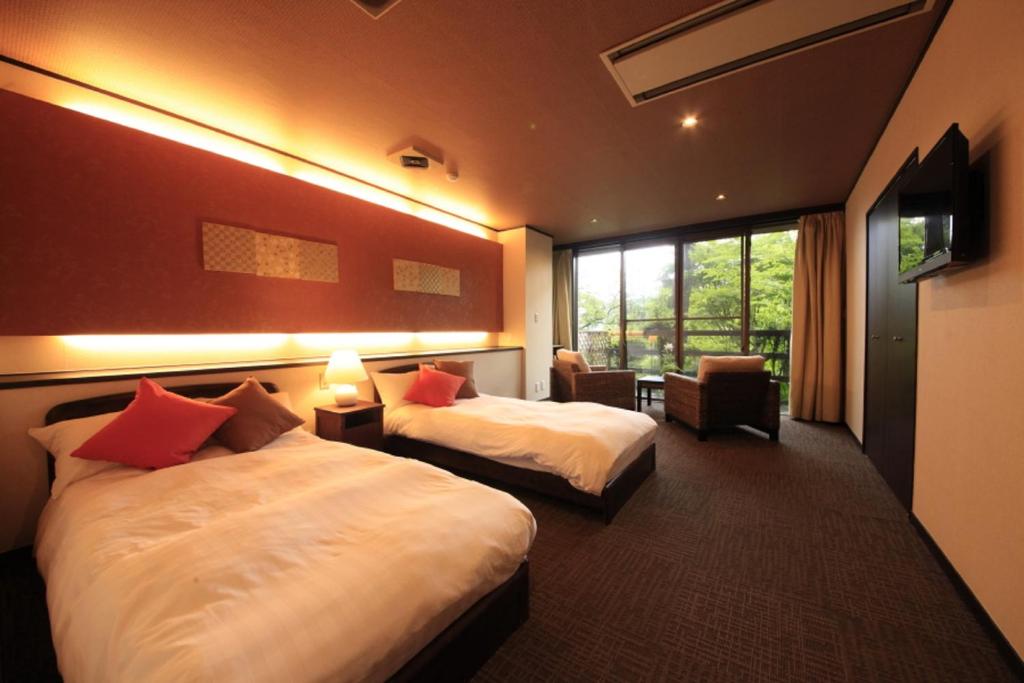 une chambre d'hôtel avec deux lits et une fenêtre dans l'établissement Yutorelo-an, à Hakone