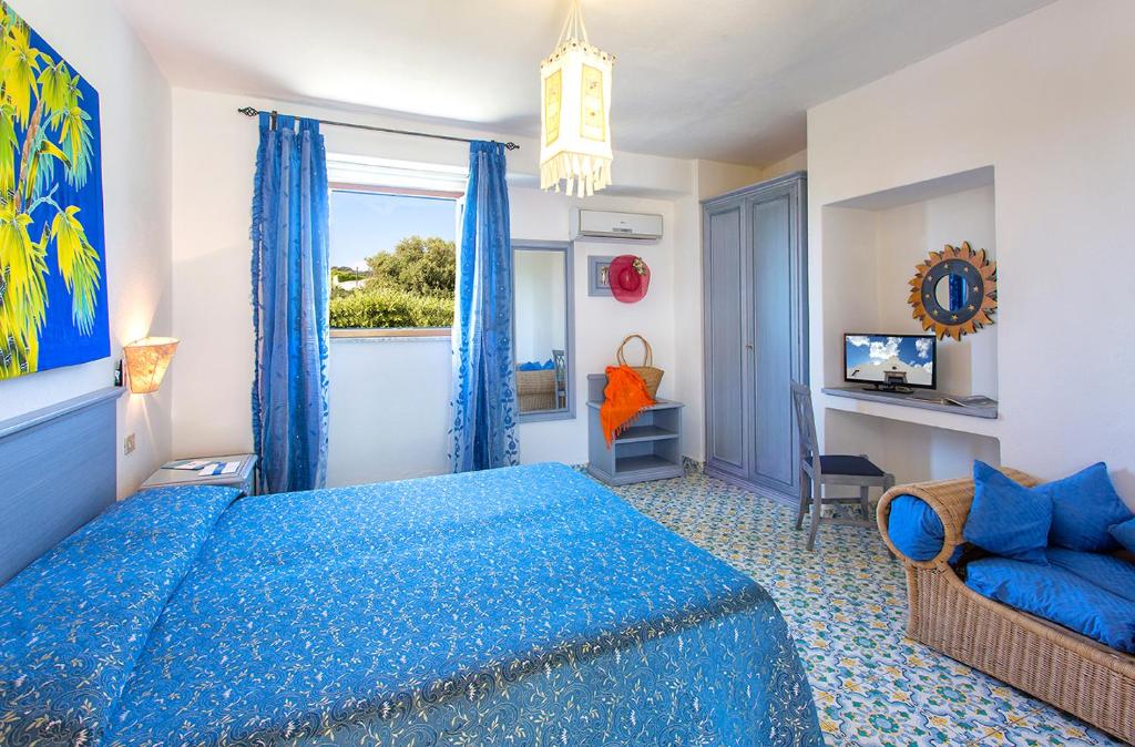 une chambre avec un lit bleu et une fenêtre dans l'établissement Hotel La Scogliera, à Ischia