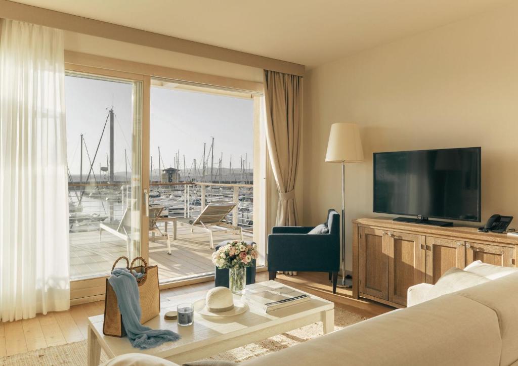 un salon avec un canapé et une grande fenêtre dans l'établissement Marina di Scarlino Resort, à Puntone di Scarlino