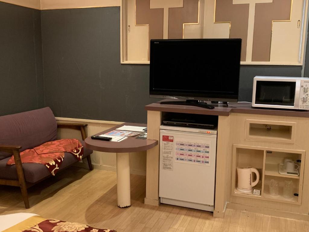 - un salon avec une télévision et une table avec une petite table sidx sidx sidx dans l'établissement JOY GARDEN, à Taku