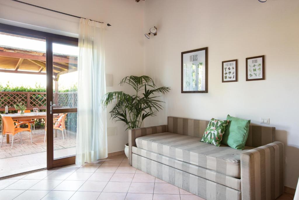 un salon avec un canapé et une terrasse dans l'établissement Hotiday Apartments Costa degli Etruschi, à Vada