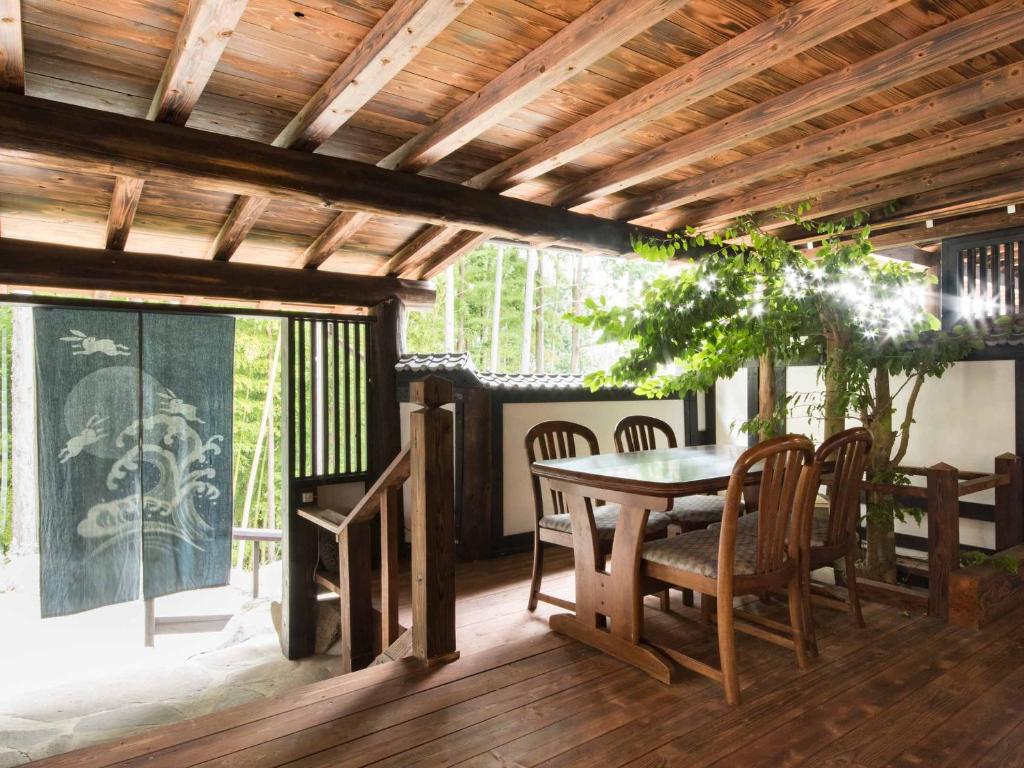 une salle à manger avec une table et des chaises sur une terrasse dans l'établissement Yokohama Fujiyoshi Izuten, à Itō
