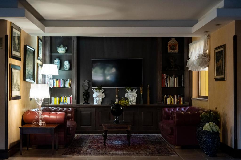 un salon avec un canapé et une télévision dans l'établissement Baia Di Ulisse Wellness & Spa, à San Leone
