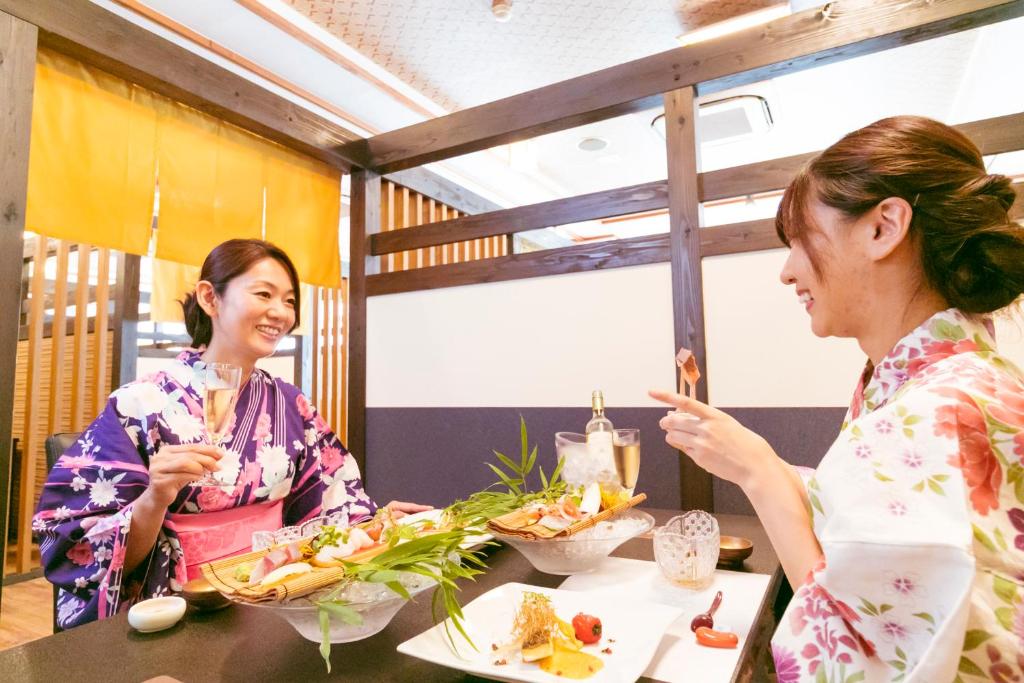 deux femmes assises à une table en train de manger dans l'établissement Ureshino Motoyu, à Ureshino