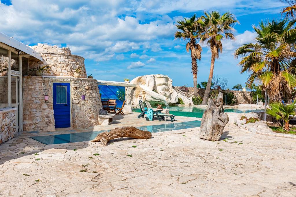 une piscine dans un complexe hôtelier avec des palmiers dans l'établissement Il Trullo al Mare -Trullo by the sea- Pool & Beach, à Molfetta