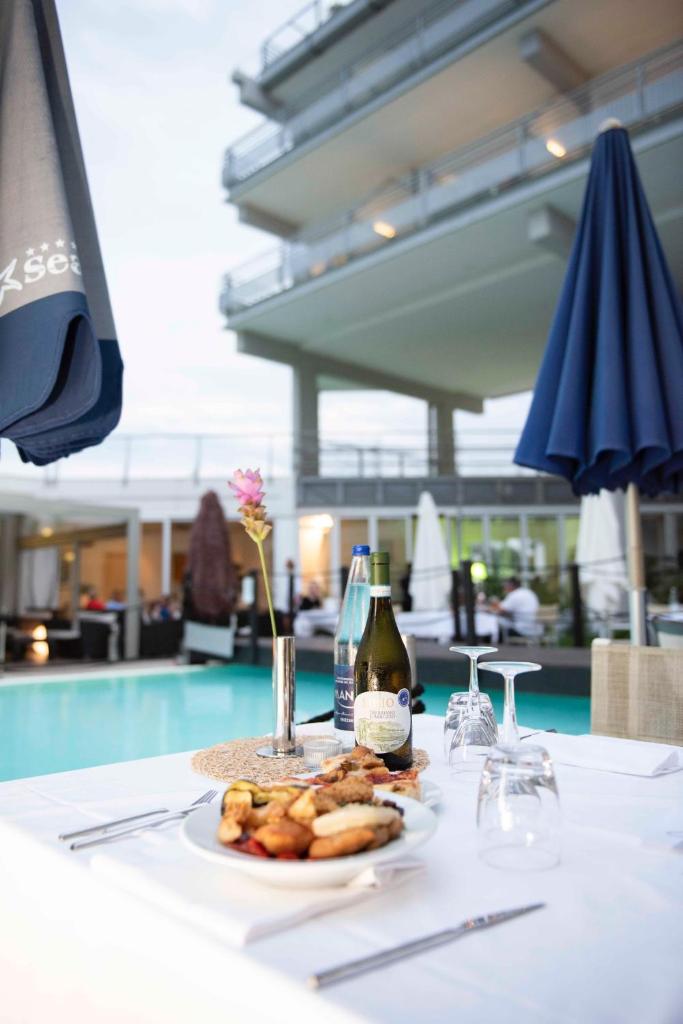 - une table avec une assiette de nourriture et une bouteille de vin dans l'établissement SeaPark SPA Resort, à Giulianova