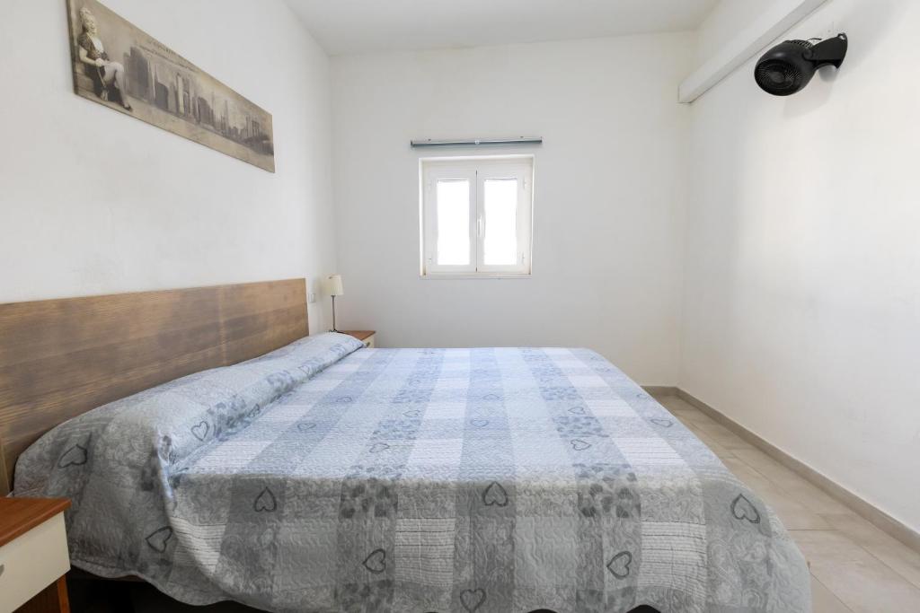 - une chambre avec un lit doté d'une couette bleue et blanche dans l'établissement Maison Marie, à Vieste