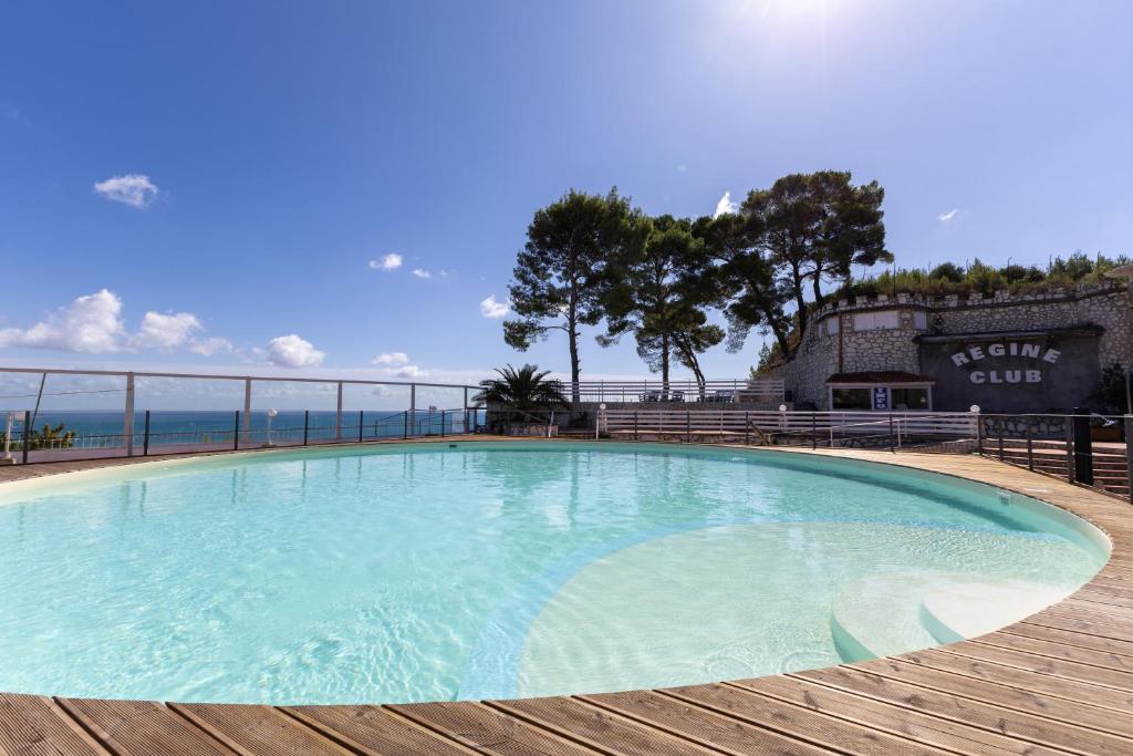une grande piscine sur une terrasse en bois dans l'établissement Residence Regine Club, à Vieste
