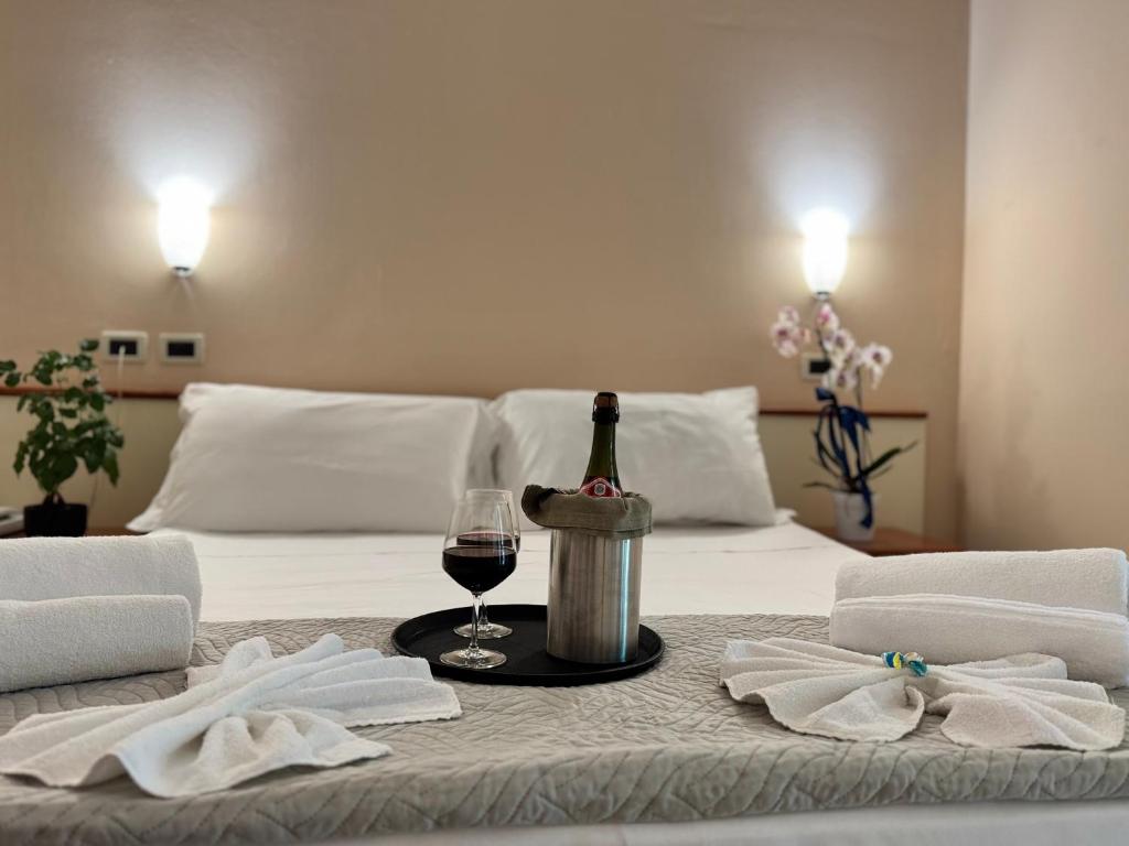 - une bouteille de vin et un verre sur le lit dans l'établissement Depandance Blue Hotel, à Cesenatico 51 autres photos