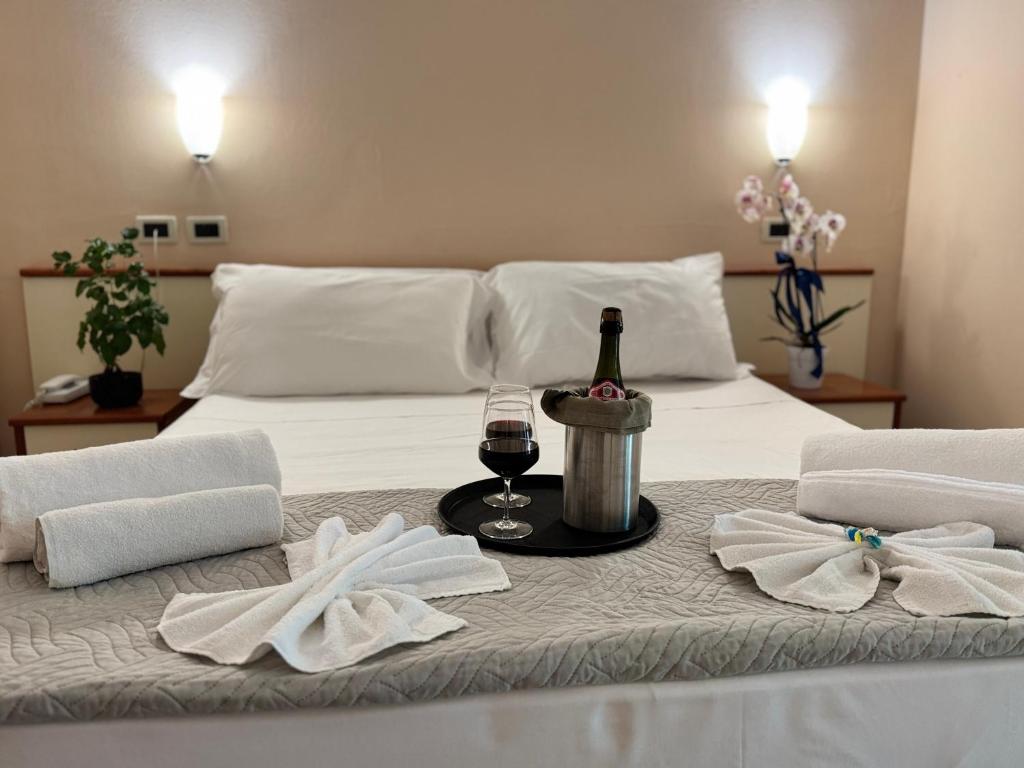 - un lit avec une bouteille de vin et un verre dans l'établissement Depandance Blue Hotel, à Cesenatico