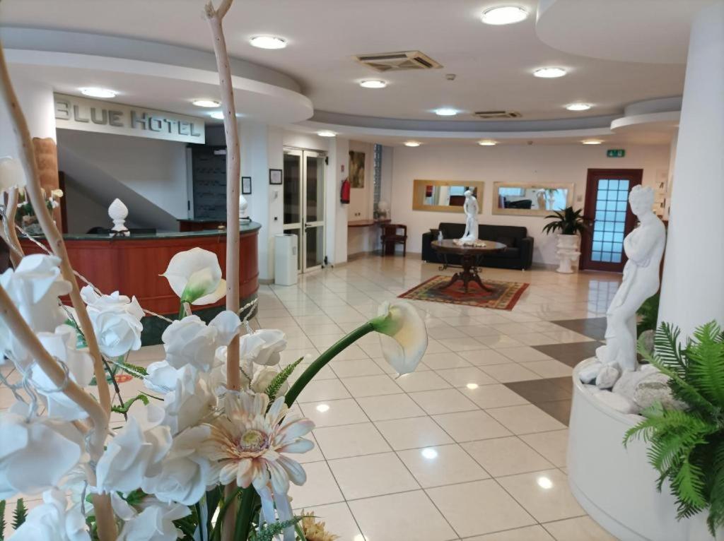 un hall d'entrée orné de fleurs blanches et une salle d'attente dans l'établissement Depandance Blue Hotel, à Cesenatico