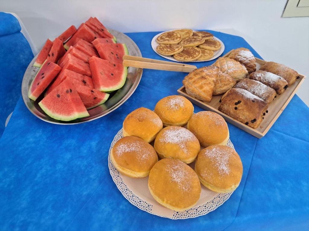 une table recouverte d'assiettes de pain, de pastèques et de pâtisseries dans l'établissement Hotel Ponte, à Vieste