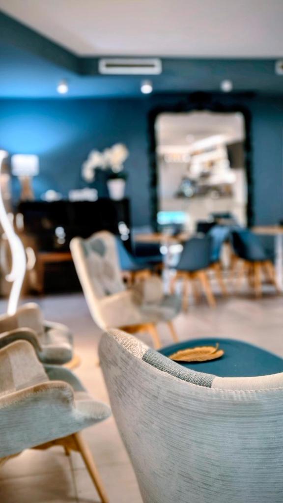 un groupe de chaises dans une pièce avec un piano dans l'établissement Hotel D'Atri, à Montesilvano