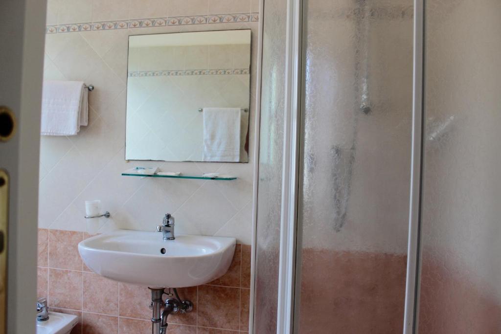 une salle de bain avec un lavabo et une douche dans l'établissement King Hotel, à Cesenatico