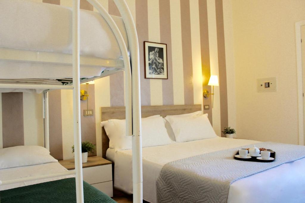 une chambre avec deux lits et un lit superposé dans l'établissement King Hotel, à Cesenatico