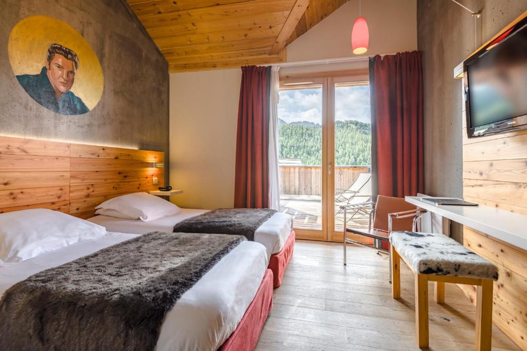 une chambre d'hôtel avec deux lits et une télévision dans l'établissement Anova Hotel & Spa, à Montgenèvre 37 autres photos
