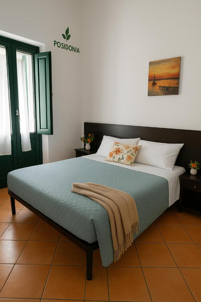 une chambre avec un lit avec une couverture dessus dans l'établissement Hotel Poseidonia, à Sapri