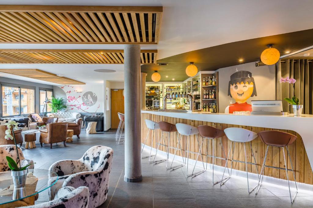 - un hall doté d'un bar avec des chaises et des tables dans l'établissement Anova Hotel & Spa, à Montgenèvre