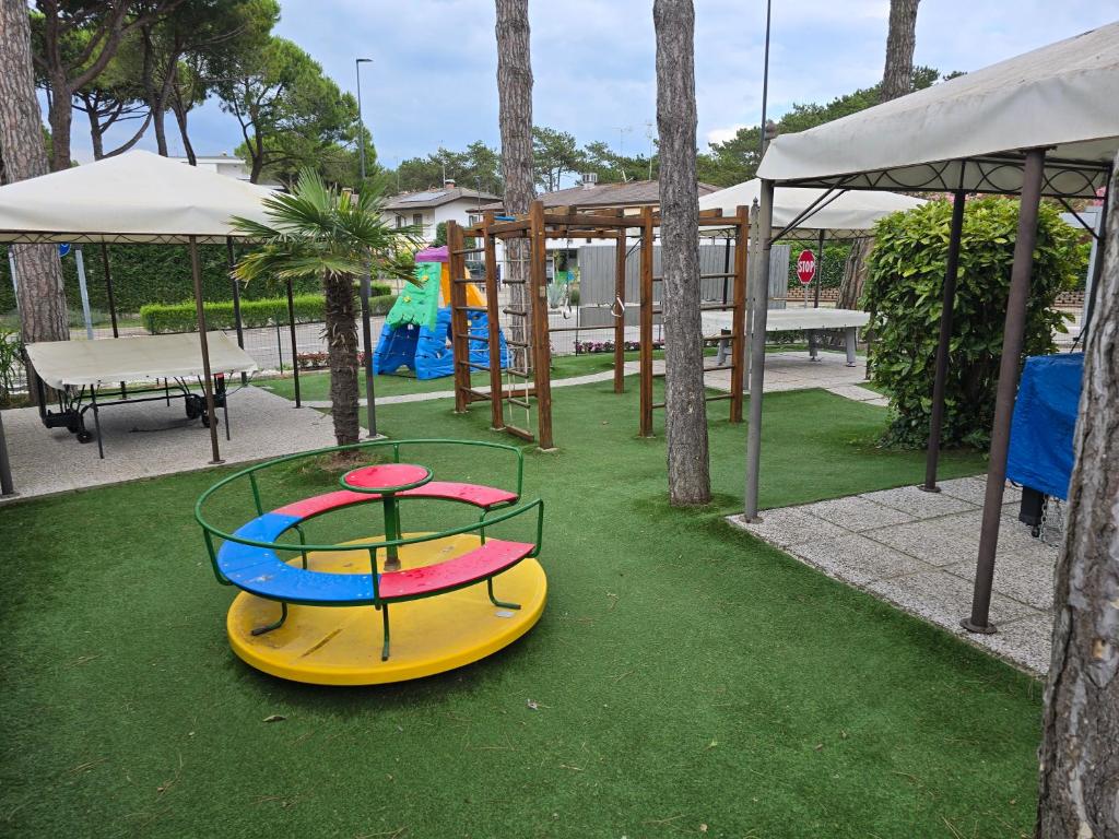 - un parc avec une aire de jeux dotée d'une table et d'un trampoline dans l'établissement Hotel Vina De Mar, à Lignano Sabbiadoro